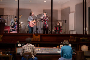Band members performing live onstage in Stereophonic