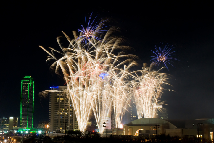Colorful fireworks display in Dallas, Texas celebrating New Years Eve. Business district and office buildings in background.