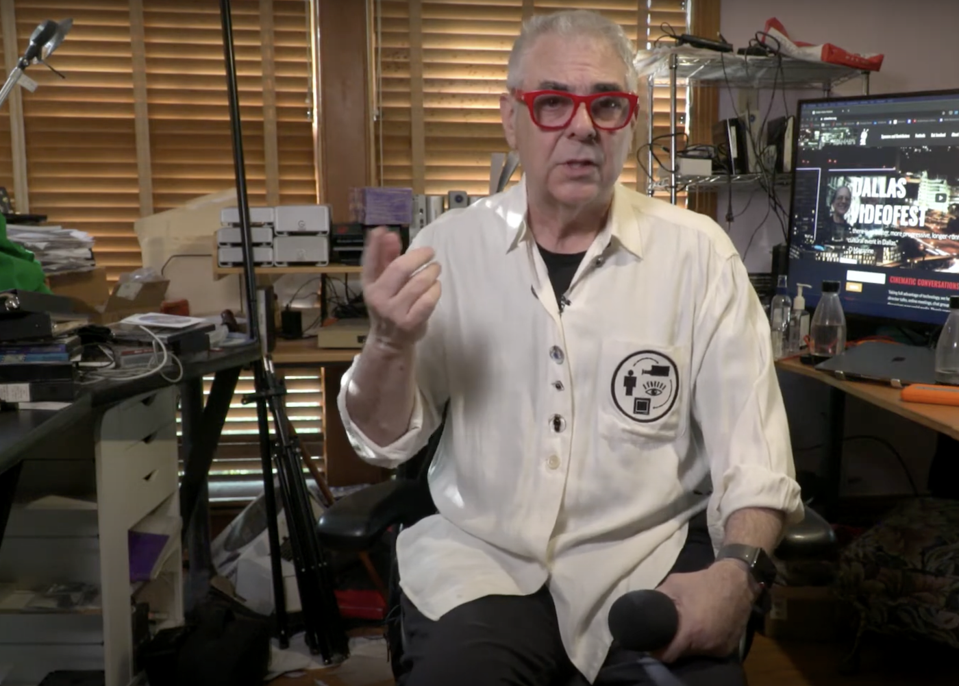 A man in a podcast studio holding a microphone